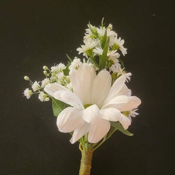 White daisy boutonniere with small filler flowers on a wrapped stem