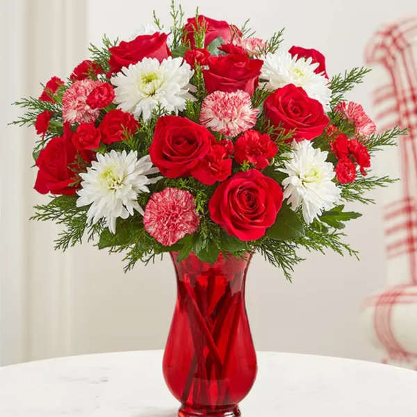 Red roses and white daisies in a red glass vase