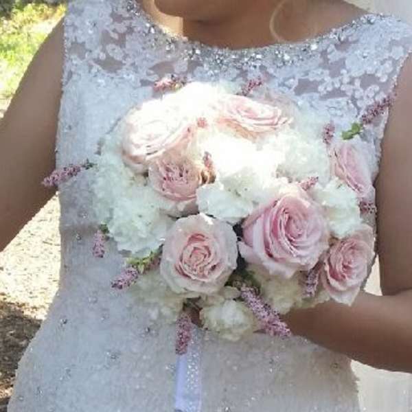 Bride holding a bouquet of pale pink roses and white flowers