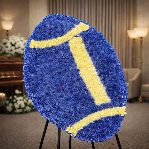 Large blue and yellow floral standing tribute on an easel