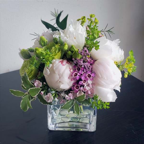 White and pink bouquet in a clear square glass vase