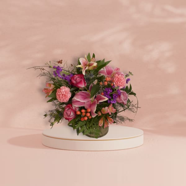 Pink and purple mixed flower arrangement in a glass vase