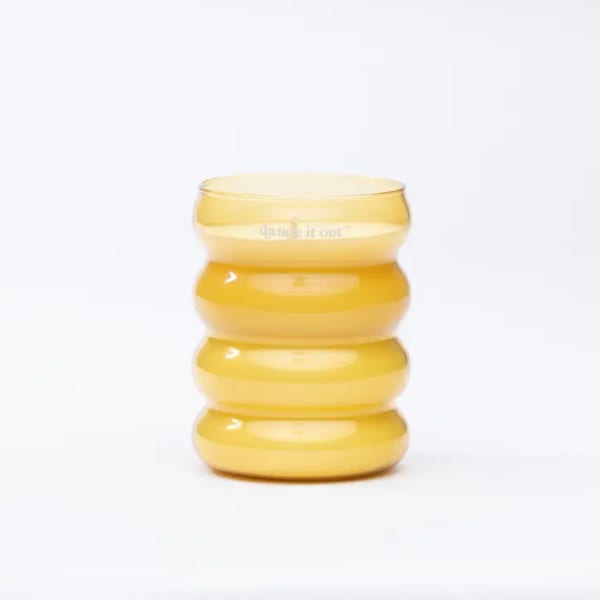 Yellow ribbed glass vase on a white background