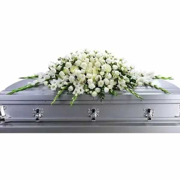 White floral casket spray on a silver casket