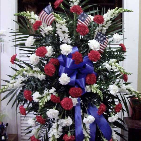 Standing floral spray with red and white carnations and small American flags