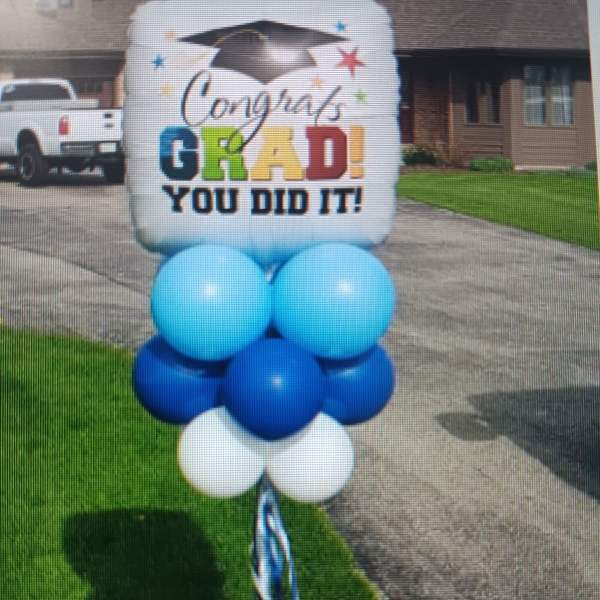 Graduation yard sign with blue and white balloons