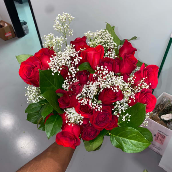 Handheld bouquet of red roses with white baby's breath