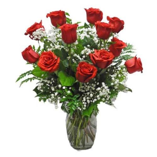 Red roses arranged in a glass vase with white baby's breath