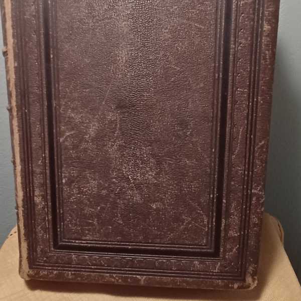 A worn brown rectangular decorative panel with raised border details