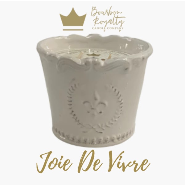 White decorative candle jar with gold logo and text