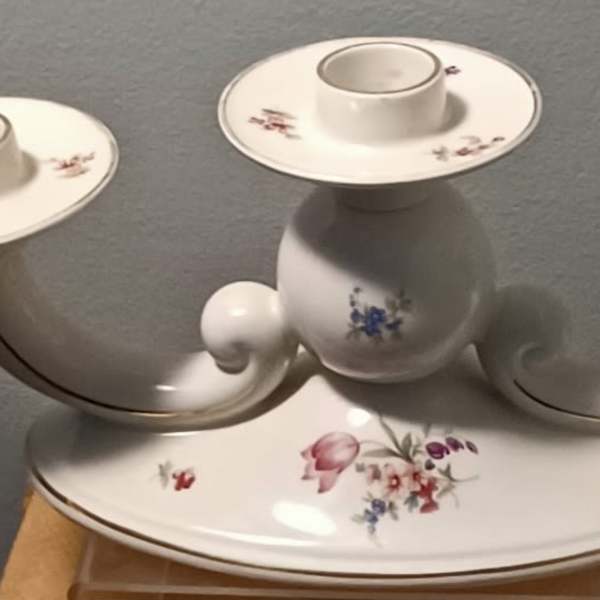 White ceramic three-arm candle holder with small floral decals