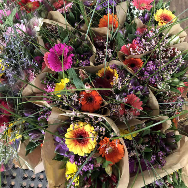 Bouquets of colorful gerbera daisies wrapped in brown paper