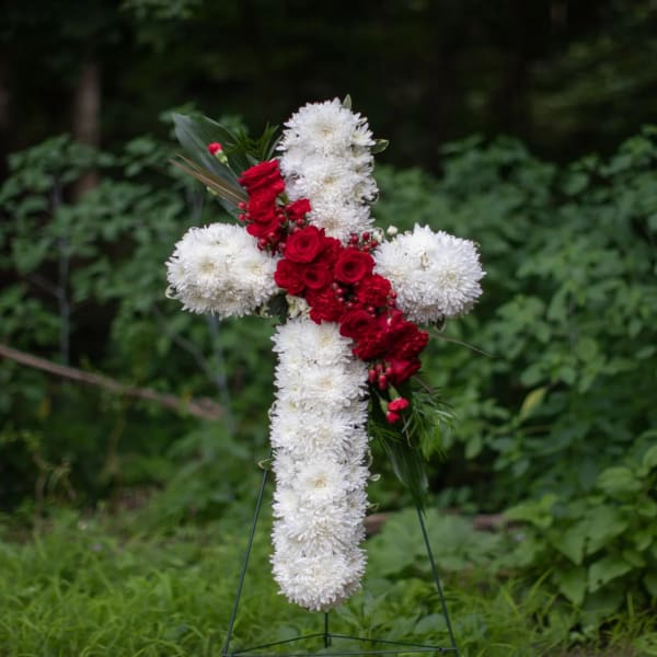 White and red floral cross on a stand
