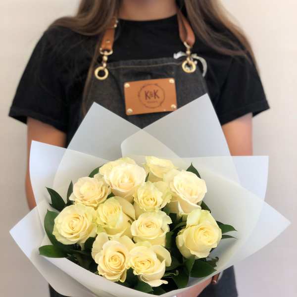 Bouquet of pale yellow roses wrapped in white paper