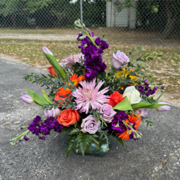 Mixed bouquet in a glass vase with purple, pink, orange, and white flowers