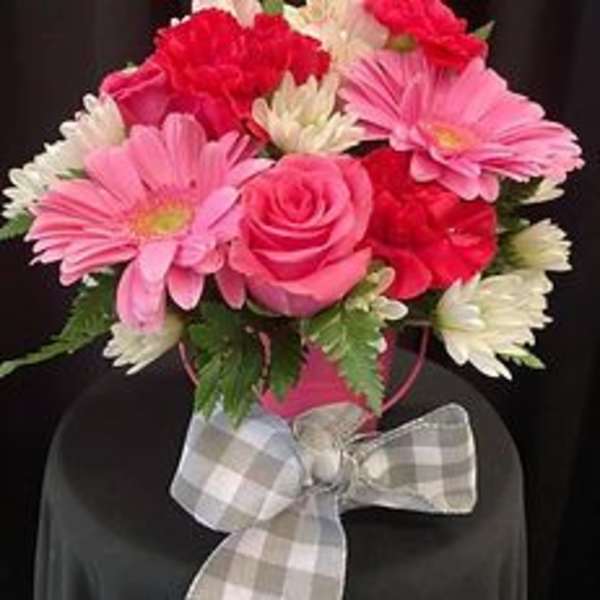 Pink and red bouquet with daisies and roses, tied with a plaid bow