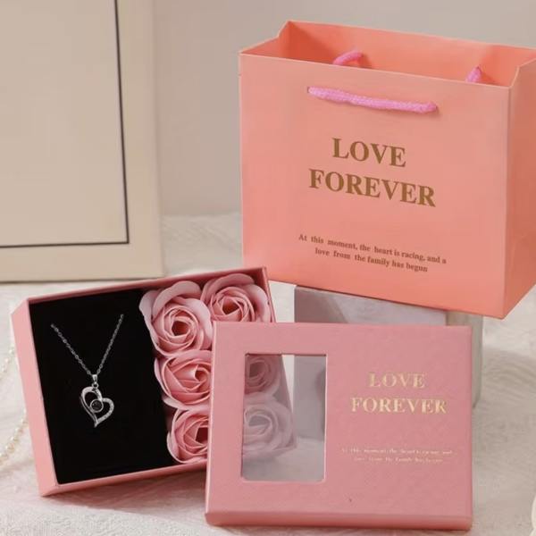 Pink gift boxes with faux roses and a heart necklace
