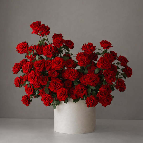 Large bouquet of red roses in a white cylindrical vase