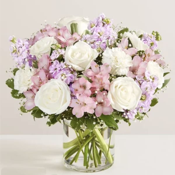 Bouquet of white roses and pink flowers in a clear glass vase