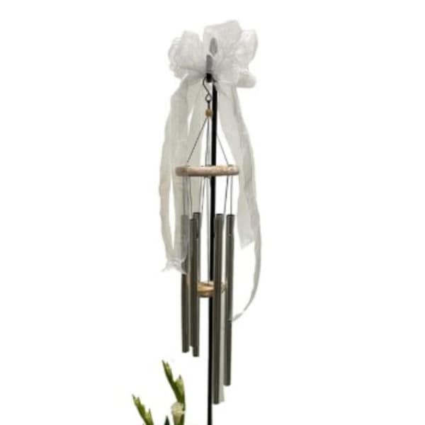 White ribbon-tied wind chime hanging on a black stand