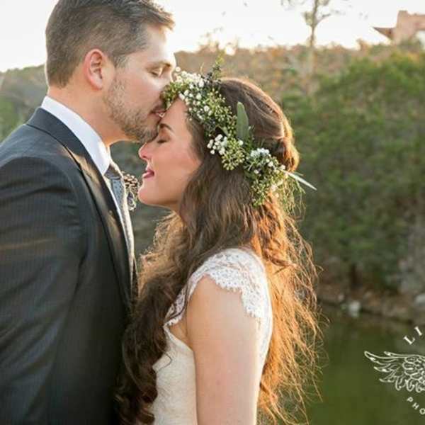Bride and groom in an outdoor kiss, with a floral crown on the bride