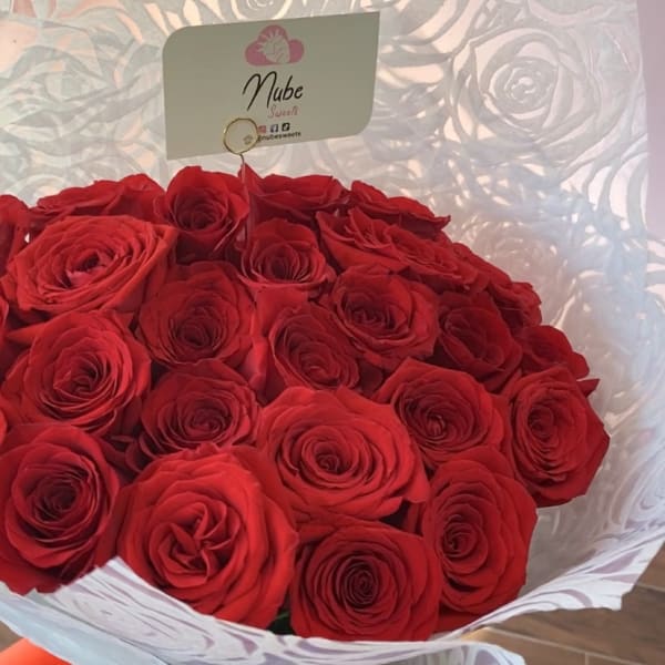 Bouquet of red roses wrapped in white paper with a red ribbon