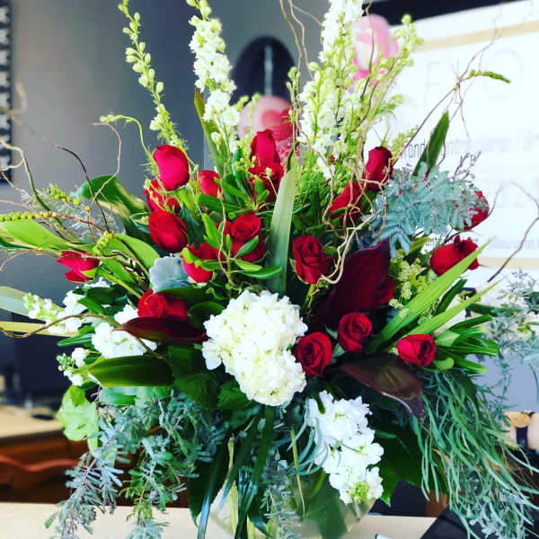 Large bouquet of red roses and white flowers in a glass vase