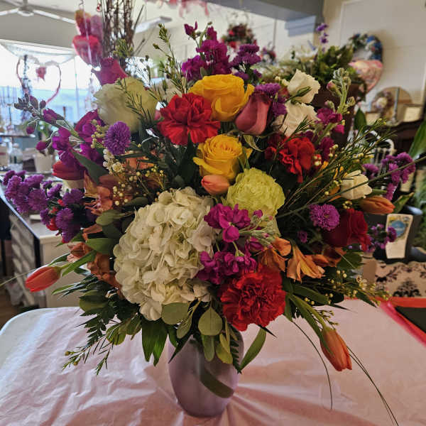 Mixed bouquet of roses, hydrangea, and tulips in a vase