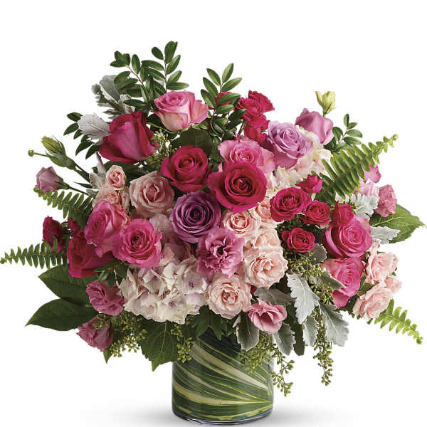 Pink and purple rose bouquet in a green glass vase