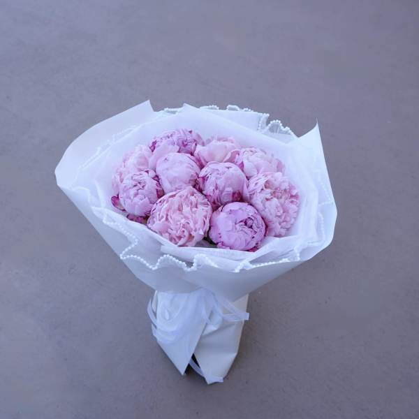 Bouquet of pink peonies wrapped in white paper