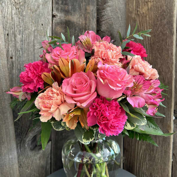 Pink roses and carnations in a glass vase