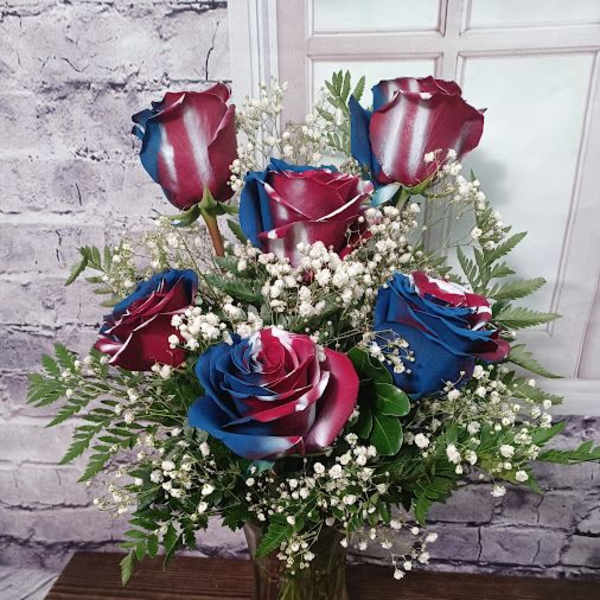 Bouquet of red, white, and blue roses in a glass vase