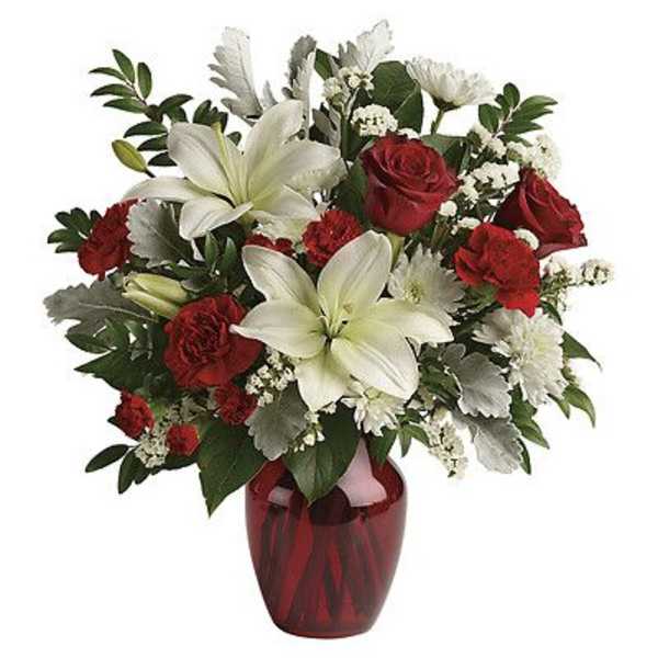 Red roses and white lilies arranged in a red glass vase