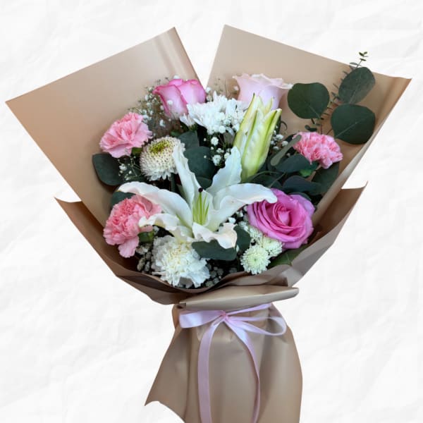 Bouquet of pink and white flowers wrapped in brown paper with a pink ribbon