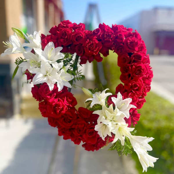 Heart-shaped arrangement of red roses with white lilies