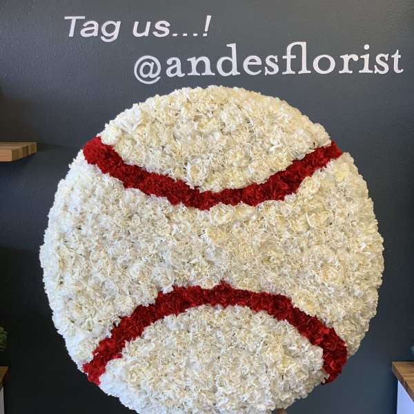 Large round floral display of white and red carnations on an easel