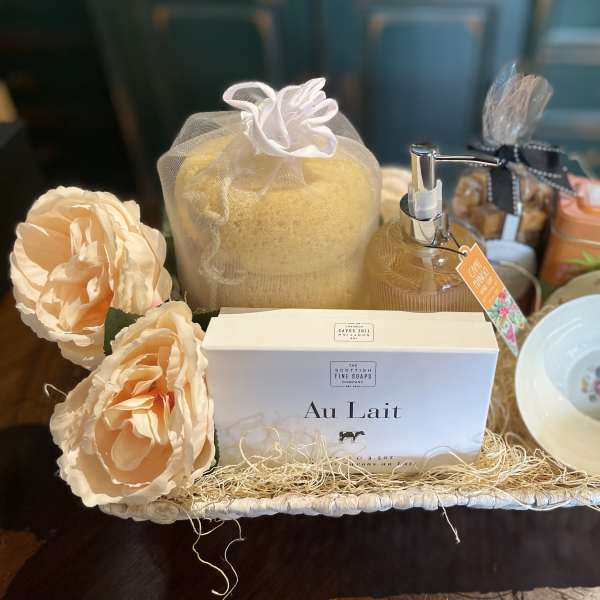 Gift basket with soap, lotion, tea, cups, and peach flowers