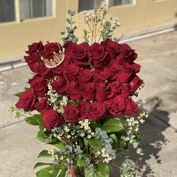 Bouquet of red roses in a glass vase with small white filler flowers