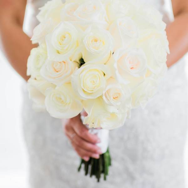Bride holding a bouquet of white roses