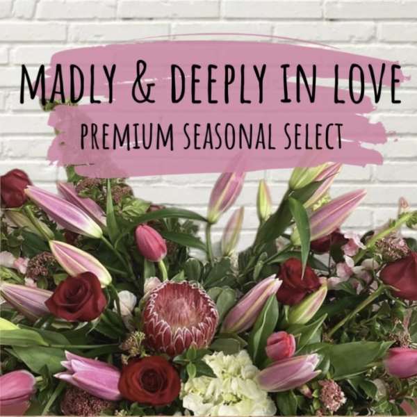 Bouquet of pink lilies, red roses, and a protea