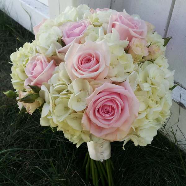Pink roses and cream hydrangeas in a hand-tied bouquet