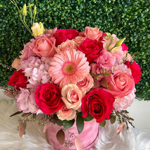 Pink and red rose bouquet with a gerbera daisy in a pink hatbox