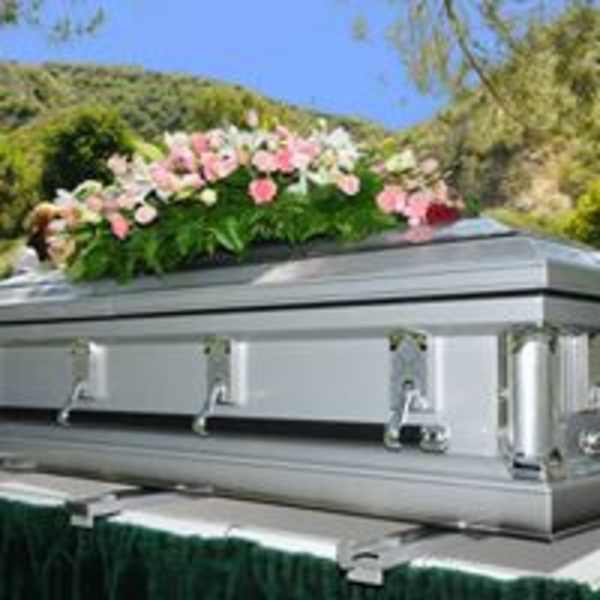 Silver casket topped with pink and white flowers