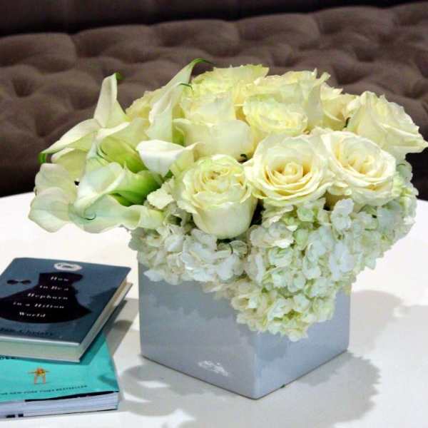 White roses and calla lilies in a square vase