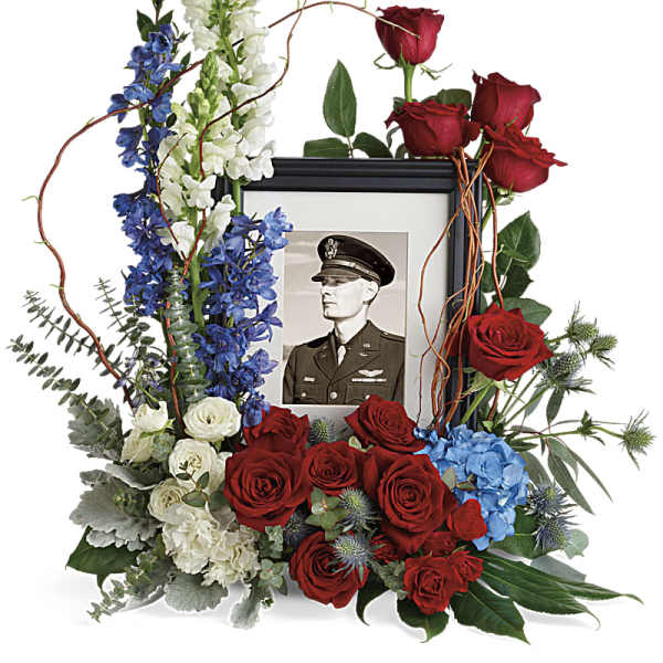 Memorial floral frame with red roses, blue delphinium, and white snapdragons