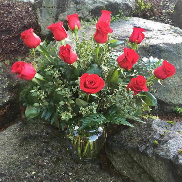Red roses arranged in a clear glass vase