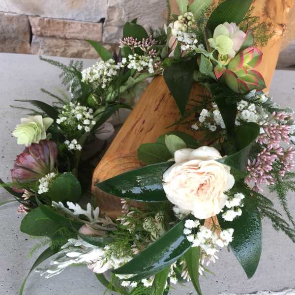 Delicate floral crown with a blush rose, white fillers, and green succulents.