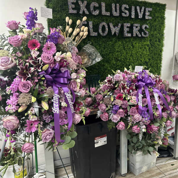 Large purple floral standing sprays with ribbon bows