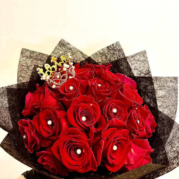 Bouquet of red roses with a small gold crown topper