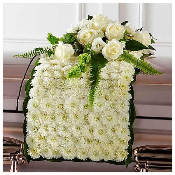 White rose and chrysanthemum floral arrangement on a casket
